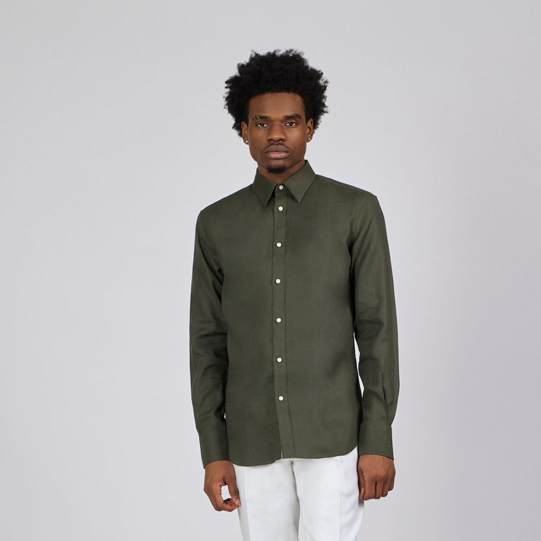 Man wearing a green shirt and white pants on a gray background