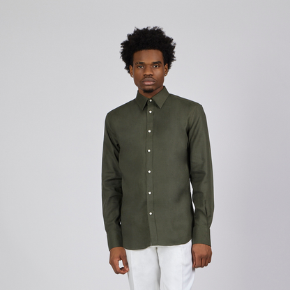 Man wearing a green shirt and white pants on a gray background