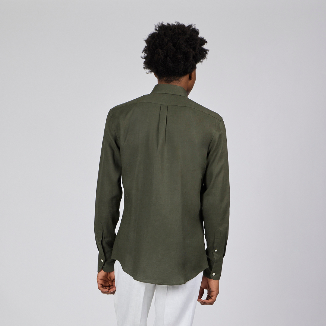 Person wearing a green shirt and white pants on a gray background