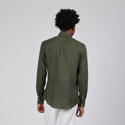 Person wearing a green shirt and white pants on a gray background